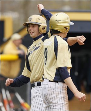 Matt Vollmar, left, celebrates with Jesse Adams after scoring a run. Vollmar, a senior, is hitting .492 with 26 RBIs.