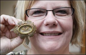 Amy Aschemeier, a volunteer at the closed St. Vincent de Paul Society's downtown thrift shop, shows a first-class relic of the saint for whom the organization is named. Known for aiding the poor, he died in 1660.