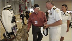 WWII test pilot Tony Barnum shows off his white uniform to Navy Lt. Commander Dean Moeller and his wife, Lt. Diana Moeller, during the WWII Stage Door Canteen event.