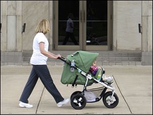 A woman pushes a child in a stroller in Parma, Ohio. 