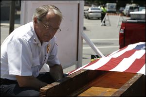 Toledo Fire Department Chief Mike Wolever sits next to the flag-draped I-beam from the World Trade Center as it travels from New York through Toledo to Wauseon, Ohio.