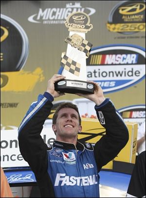 Carl Edwards hoists the winners trophy after the Nationwide Alliance Truck Parts 250.