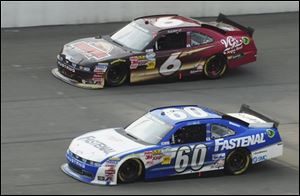 Carl Edwards (60) passes teammate Ricky Stenhouse Jr. with less than 10 laps remaining on his way to winning the NASCAR Nationwide Series Alliance Truck Parts 250 at Michigan International Speedway.