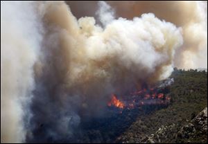 Smoke rises from the evacuation area near State Route 92 and East Ramsey Canyon Road as a wildfire burns near Sierra Vista, Ariz.