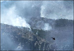 The battle against the Monument fire takes to the air Monday. Air crews had been grounded for most of Sunday. Firefighting efforts have been dogged for days by hot, windy weather. 
