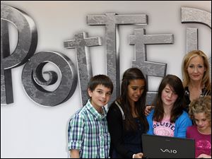 British author J.K. Rowling, back right, poses for photographers with children as she announces her new website project Pottermore at the Victoria and Albert Museum in London.