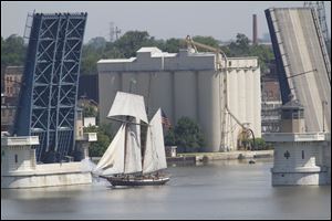 The ship fires a cannon as it sails through the raised Cherry Street bridge.