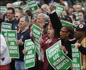 University of Toledo records management worker Jackie Rome, fist in air at right, attends a pro-union and anti-SB 5 rally earlier this year at UT.