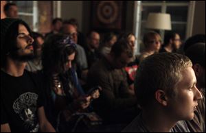 The audience fills the large rectangular living room of Gabe Beam’s concert house.