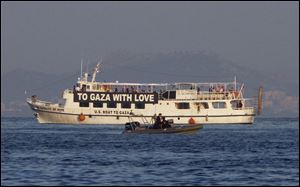 The activist run boat named 'Audacity of Hope,' right, is escorted by the Greek coast guard in port of Perama, near Athens, Greece, Friday. Greek authorities have arrested the ship's captain.