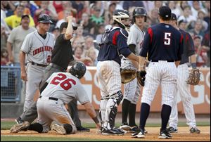 Third base umpire Gerard Ascani calls Indianapolis' Jordy Mercer (19) out after Matt Hague (26) was chased back by the Hens' Max St-Pierre.