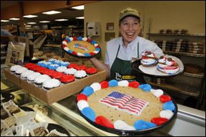 Bakery manager Linda Jones displays holiday-themed cookies and cupcakes for sale at The Andersons in West Toledo.
