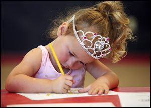 Reese Brennan, 3, prefers to wear her crown during a Safe-T-City class in Crossroads Community Church in Ottawa Lake, Mich. At the new school also, the Montessori method will let children learn in a relatively unstructured environment.