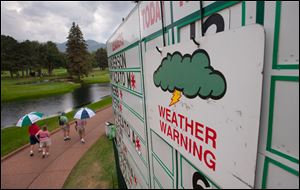 Spectators leave after thunderstorms halted play at the U.S. Women's Open in Colorado Springs.