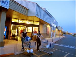 Extreme coupon cutters and users Monica Knight, left, and Cathy Yoder leave an Albertsons grocery store in Boise. The duo blog and teach classes about extreme couponing. 