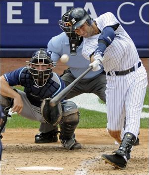 The Yankees' Derek Jeter hits a home run for his 3,000th career hit during the third inning of a baseball game against the Tampa Bay Ray at Yankee Stadium in New York. 