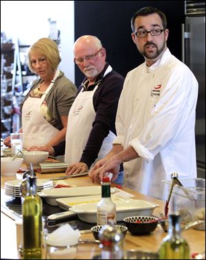 Pegg and Dick Bisher watch as Chef Paul Kendall, right, demonstrates cooking techniques during a class at the Learning Kitchen in West Chester, Ohio. A pair of suburban Cincinnati mothers who have a love of food founded the company three years ago. The National Restaurant Association predicts growth for chefs and head cooks over the next decade.