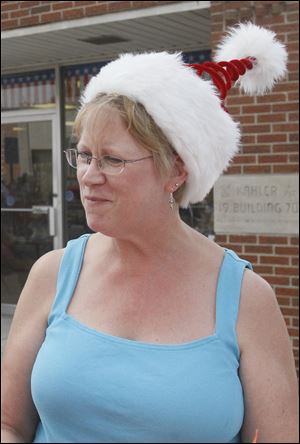 Sheila Swartz tops her summery outfit with a spiral Santa hat on Front Street. She was one of many people attending the annual celebration that blends winter-holiday atmosphere, decorations, and music with warm-weather relaxation.
