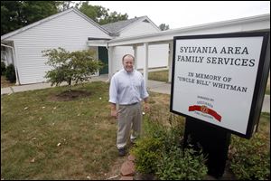 Jason Robertson, the executive director of the Sylvania Area Family Services, stands in front of the building that will be torn down and replaced where a new $500,000 building expansion will be.