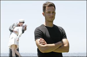 Sean Sala poses in front of a statue of a Navy sailor kissing a nurse in San Diego. Sala, a former sailor, is organizing a military contingent of hundreds of former and active-duty troops Saturday to lead San Diego's Gay Pride March, in a show of unity to honor those who serve the country and have died for it. 