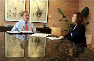 Ray Stranghoener, left, president of the Commerce Trust Co., a unit of Commerce Bank, discusses strategy with Vice President Cathleen Arshadi. The bank has added services and staff to its  Family Office this year to serve 75 families who have more than $25 million in assets not including their houses. 