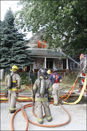 Toledo firefighters standby as water is poured on a fire on Buffalo Street Thursday night. 