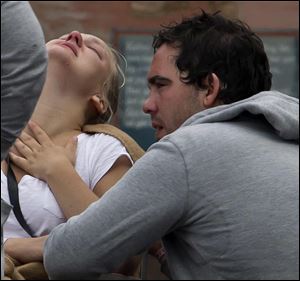 Unidentified survivors from the shooting at an island youth retreat are overcome with emotion Saturday outside a hotel where survivors were being reunited with their families in Sundvolden, Norway.