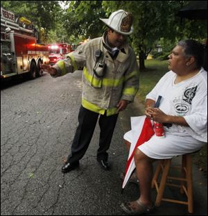 Ex-Toledo City Council president Louis Escobar speaks with Toledo Fire Chief Luis Santiago after evacuating his South Toledo home.