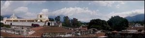 La Merced Church, with its striking yellow-and-white stucco facade, sits high atop the city of Antigua, with Agua Volcano looming in the background.