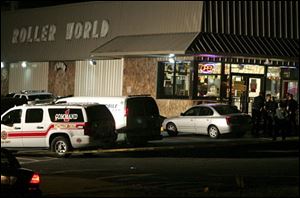 Emergency personnel wait outside the scene of a shooting at a roller rink in Grand Prairie, Texas. A police chief says a gunman has died of a self-inflicted gunshot wound after killing five other people and injuring three at the roller rink.
