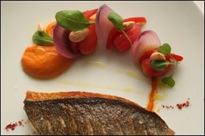 A dish of daurade in a romesco sauce.