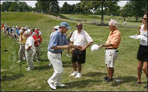 Golfer Nick Price, left, works a rope line, signing autographs Wednesday at Inverness Club in preparation for the U.S. Senior Open. Tournament play begins Thursday.