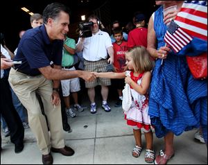 Republican presidential candidate Mitt Romney meets Sophie Sturges, 4, with neighbor Cheryl Brown, outside Screen Machine Industries in Pataskala, Ohio. 