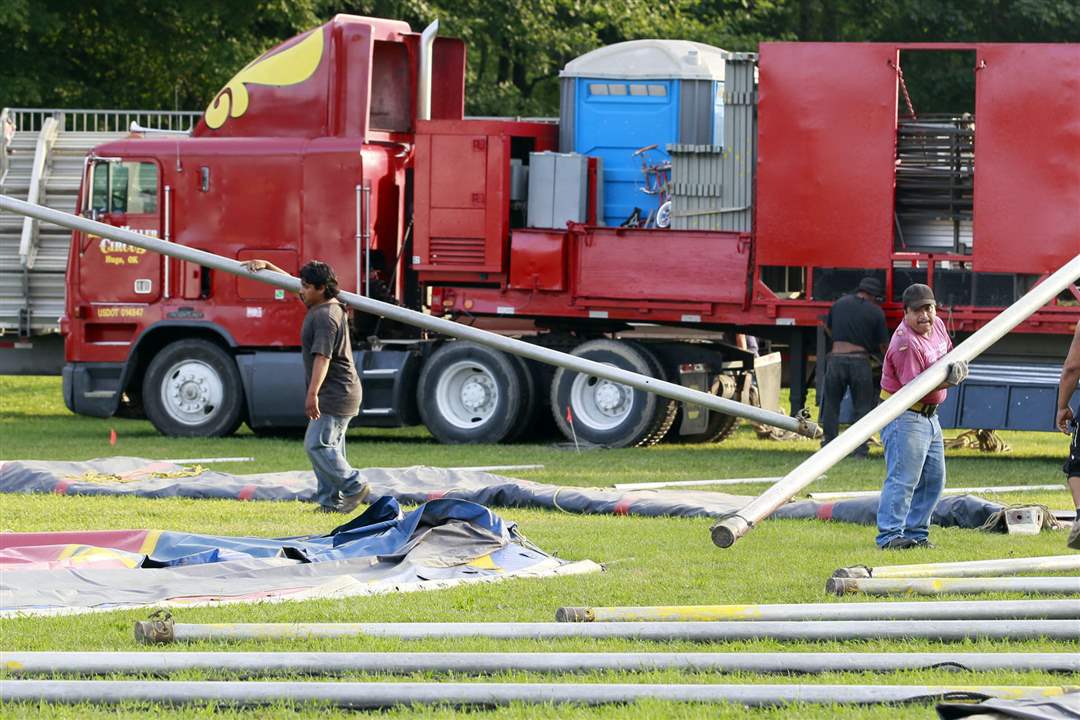 Circus-workers-carrying-poles