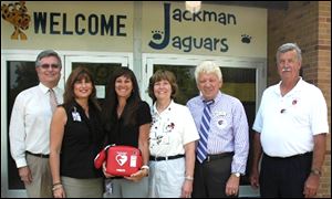 From left, Superintendent Ted Magrum, Jackman Principal Sherry Farnan, PTO President Amy Krupp, district nurse Roxann Satkowski, Bedford Township Supervisor Walt Wilburn, and Bedford Fire Chief John Bofia display the automated external defibrillator.