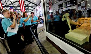 Members of the Junior Fair Board photograph a young boy made out of butter floating in space away from a replica of the space shuttle console at the Ohio State Fairgrounds on July 26.