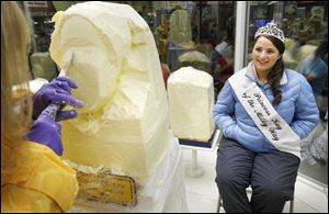 Katie Miron, the Princess Kay of the Milky Way, Minnesota's dairy queen, sits in the chilled confines of the butter sculpting cooler to get her official butter head sculpted by Linda Christensen for the Minnesota State Fair in Falcon Heights, Minn., in this Aug. 26, 2010, file photo.