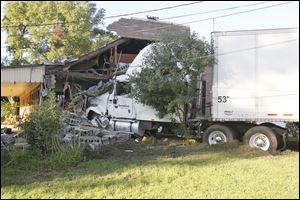 A semi is wedged into an apartment building on Maumee Western Road after swerving off to avoid collision with a car pulling out from a stop sign on Eber Road in Monclova Township, Ohio.