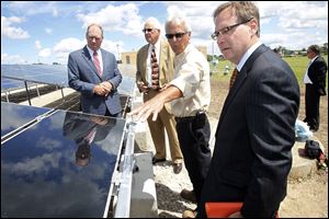 Paul Toth, left, chief executive of the port authority, with Deputy Mayor Tom Crothers, John Witte of Advanced Distributed Generations, and Kevin Moyer of the port authority, examine the solar panel array.
