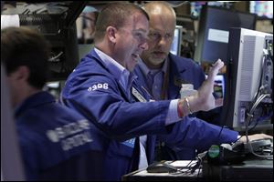 A pair of specialists work Friday at a post on the floor of the New York Stock Exchange.