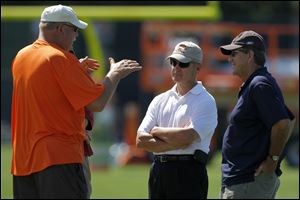 Cleveland Browns president Mike Holmgren, left, talks with former Ohio State head football coach Jim Tressel, center, and former Michigan head football coach Lloyd Carr at Cleveland Browns NFL football training camp in Berea, Ohio.