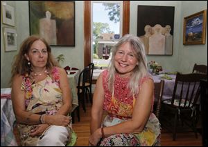 Dragonfly Tea Cottage proprietor Jennifer Blakeman, left, of Toledo, and artist Peg Stevenson, of Blissfield, Mich., in one of the rooms of the tea house and gallery. On the rear wall are paintings by Stevenson.