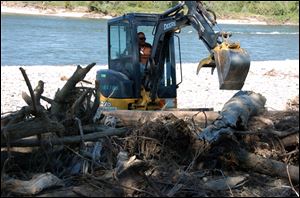 associated pressAn excavator pulls apart a debris pile along a stretch of the Yellowstone River near Billings, Mont. Oil contaminated the river when a pipeline burst in July.