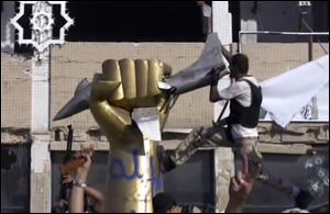 A rebel fighter climbs on a statue inside Moammar Gadhafi's compound in Tripoli in this image taken from television Tuesday.
