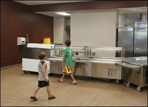 Owen Speer, 4, left, and his cousin Spencer Young, 8, an incoming third grader at DeVeaux, check out the kitchen where lunch will be served. The lunch counters were lowered at the K-8 school to accommodate younger students.