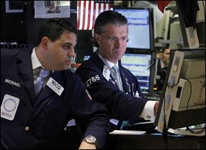 Specialists Michael Cacace, left, and Donald Civitanova work on the floor of the New York Stock Exchange Monday, Aug. 29, 2011. Stocks rose broadly Monday, led by insurance companies, after it became clear that the tropical storm caused far less damage than many had feared. The Dow Jones industrial average gained more than 250 points.