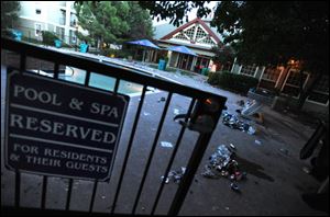 The door to the pool area hangs off its hinge, and trash and clothing  litter the area after a large party was broken up by police at the Rams Pointe apartment complex in Fort Collins, Colo. A Facebook page fueled the megaparty near Colorado State University, attended by more than 2,000. Four people were arrested and 10 hospitalized.