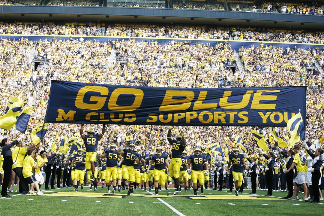 Michigan-players-charge-field-for-season-opener