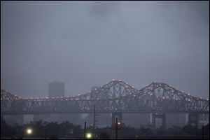Heavy rain clouds from approaching Tropical Storm Lee form over the skyline of New Orleans and the Crescent City Connection bridges at dusk Friday.