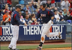 Hens first baseman Ryan Strieby is congratulated by manager Phil Nevin after crushing a home run in the eighth inning Monday.
